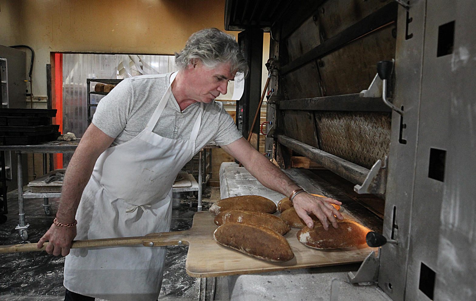 Richard Bourdon sliding sourdough into the deck oven
